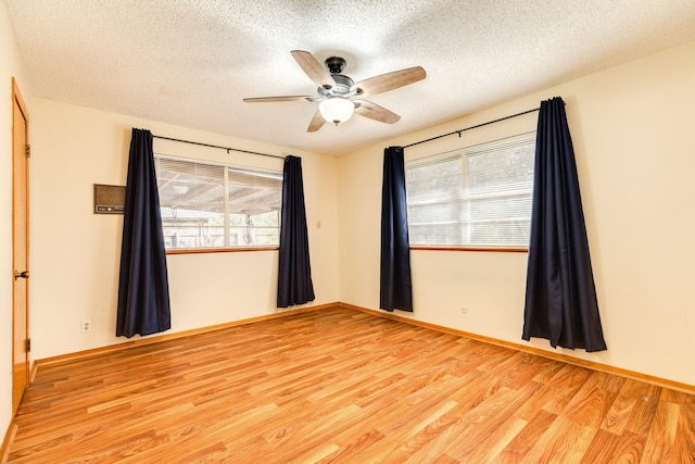 unfurnished room featuring light hardwood / wood-style floors, a textured ceiling, and a healthy amount of sunlight