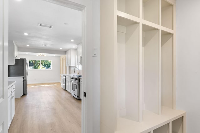 mudroom featuring sink and light hardwood / wood-style flooring