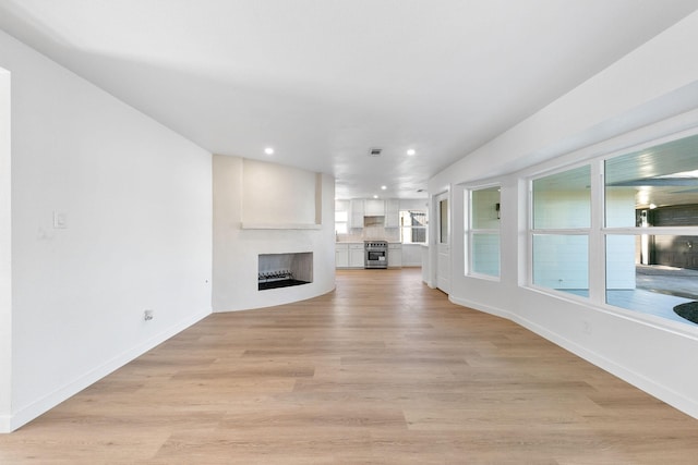 unfurnished living room featuring a fireplace and light hardwood / wood-style flooring