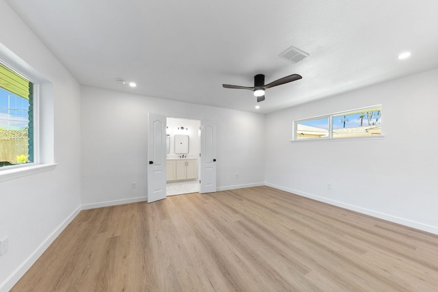 spare room featuring ceiling fan, a healthy amount of sunlight, and light wood-type flooring