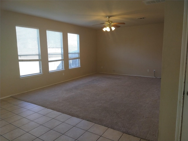 tiled empty room featuring ceiling fan