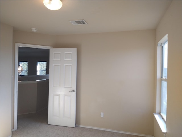 empty room featuring a healthy amount of sunlight and light colored carpet