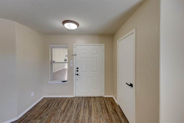 foyer entrance with a textured ceiling and dark hardwood / wood-style floors