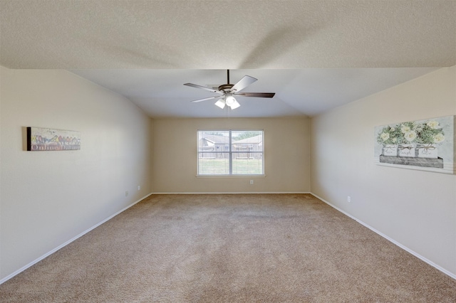 carpeted empty room featuring a textured ceiling, ceiling fan, and lofted ceiling