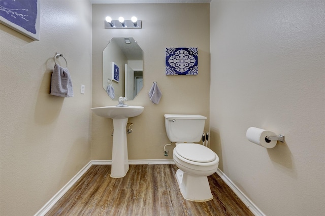 bathroom featuring wood-type flooring and toilet