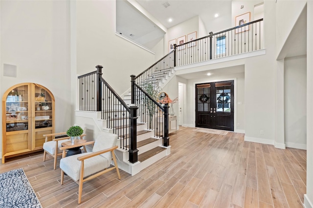 foyer entrance with a towering ceiling and french doors