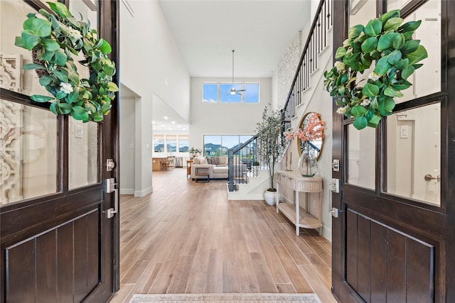 entryway featuring a high ceiling, light hardwood / wood-style floors, and an inviting chandelier