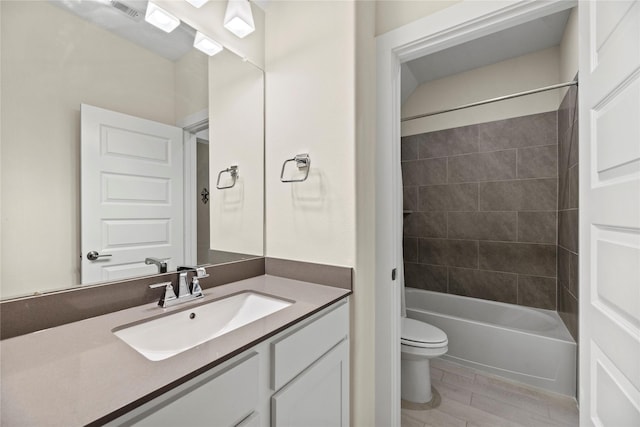 full bathroom featuring tiled shower / bath combo, toilet, and vanity