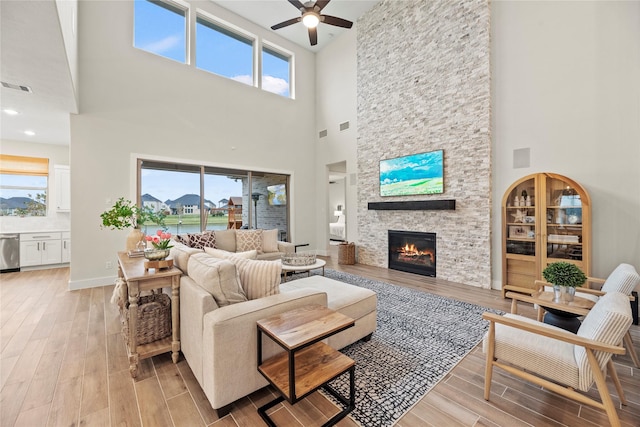 living room with a stone fireplace, a towering ceiling, and a wealth of natural light