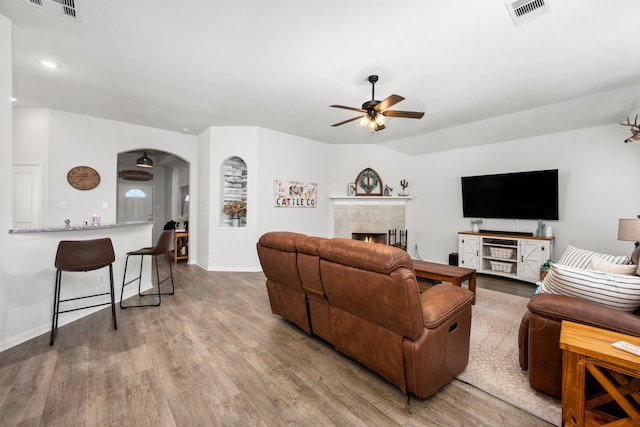 living room with a fireplace, hardwood / wood-style floors, and ceiling fan