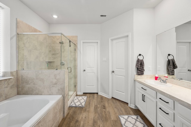 bathroom featuring wood-type flooring, vanity, and independent shower and bath