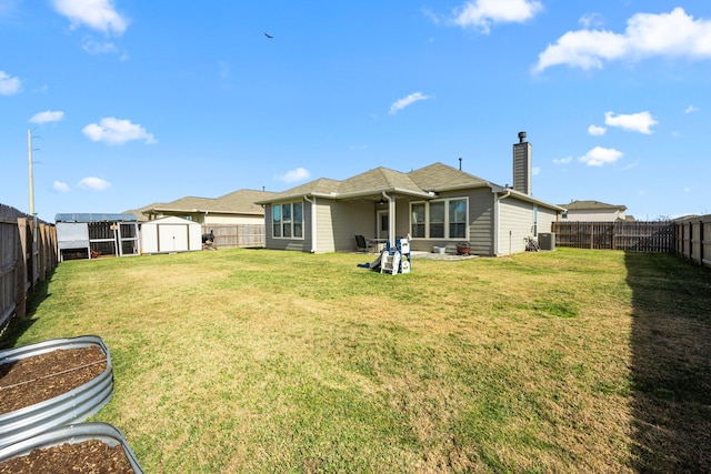 rear view of house with a yard, central AC, and a storage unit