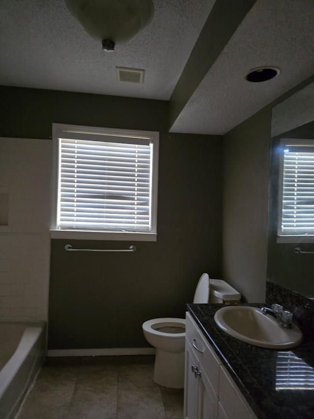 full bathroom featuring toilet, plenty of natural light, visible vents, and a textured ceiling