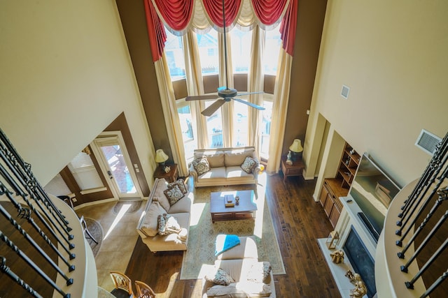 living room with a high ceiling, ceiling fan, and dark hardwood / wood-style floors