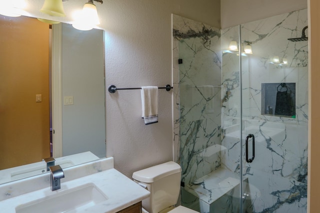 bathroom featuring toilet, vanity, and a shower with shower door