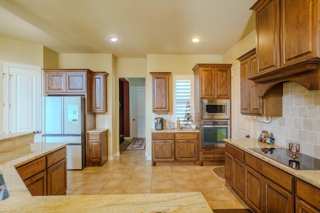 kitchen featuring stainless steel appliances, tasteful backsplash, light tile patterned floors, and light stone countertops