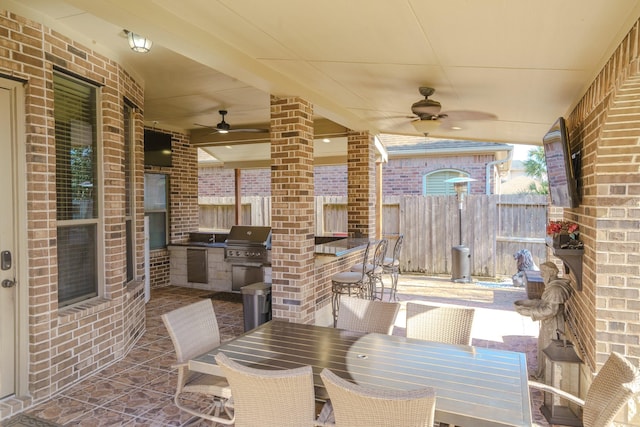 view of patio featuring exterior kitchen, a bar, ceiling fan, and a grill