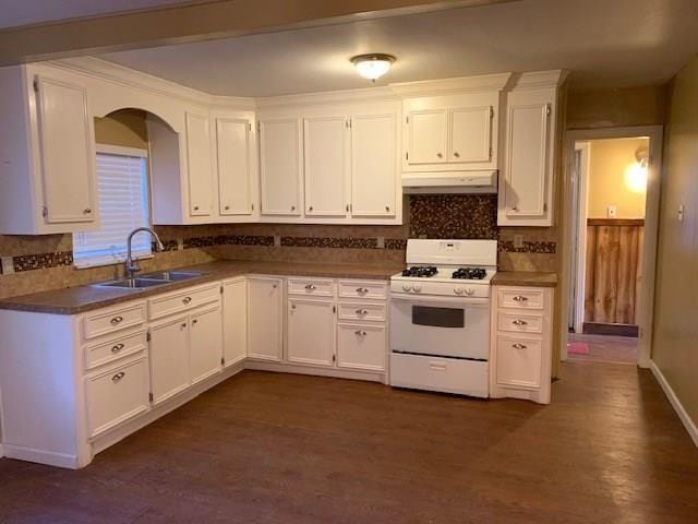 kitchen with white cabinets, backsplash, sink, and white gas range oven