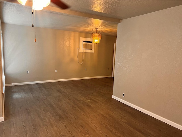 unfurnished room with an AC wall unit, ceiling fan, dark hardwood / wood-style flooring, and a textured ceiling