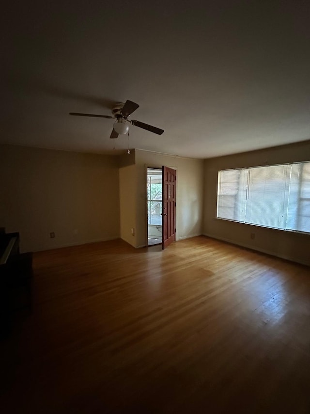 empty room with ceiling fan and light hardwood / wood-style flooring