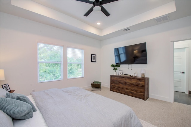 bedroom featuring a tray ceiling, ceiling fan, and carpet flooring