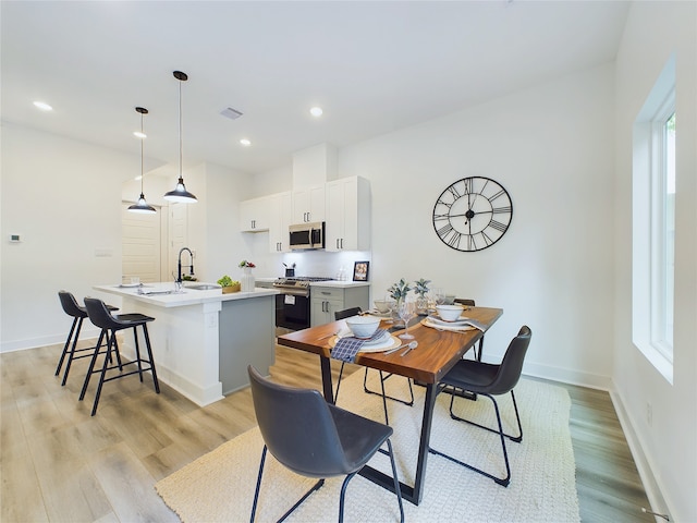 dining room featuring light wood-type flooring and sink