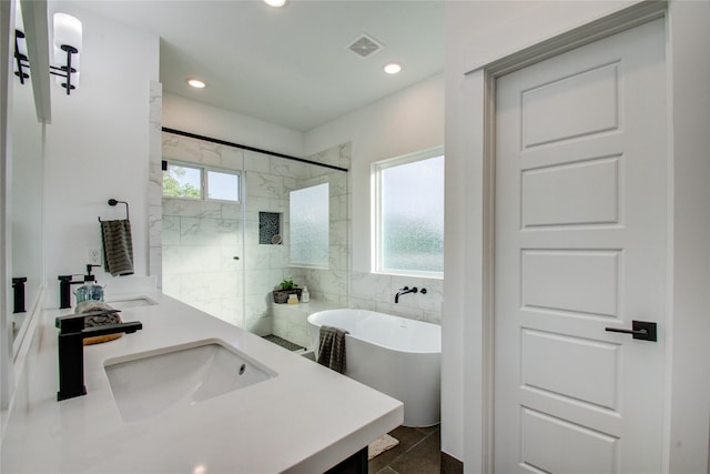 bathroom featuring tile patterned flooring, vanity, independent shower and bath, and tile walls