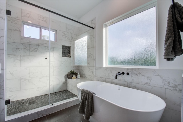 bathroom featuring a healthy amount of sunlight and tile walls