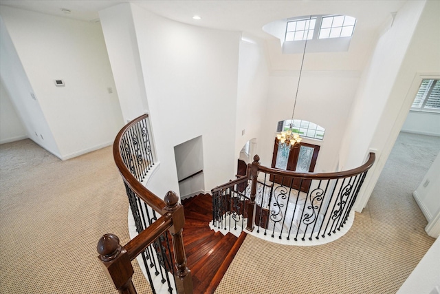 stairway with carpet, a high ceiling, and plenty of natural light