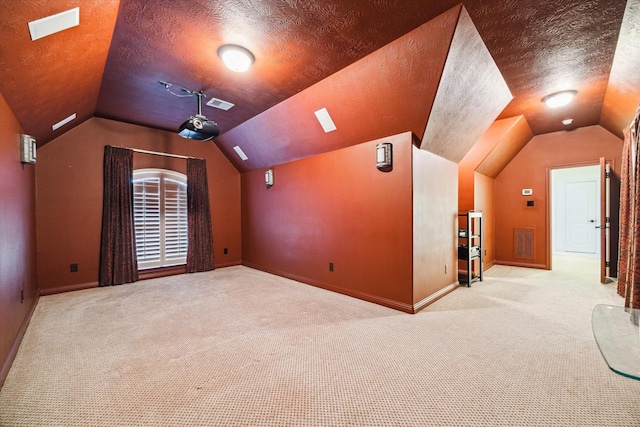 carpeted cinema featuring a textured ceiling and vaulted ceiling