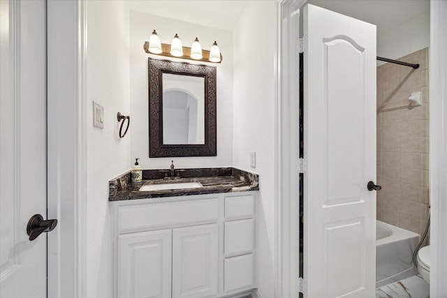 full bathroom with vanity, toilet, and tiled shower / bath