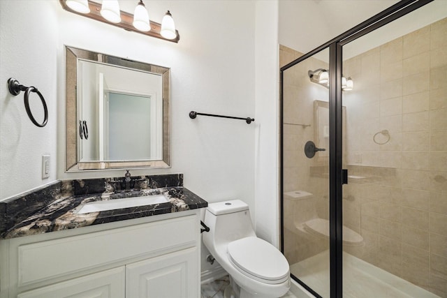 bathroom featuring vanity, toilet, and a shower with shower door