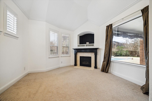 unfurnished living room featuring carpet flooring, vaulted ceiling, and crown molding