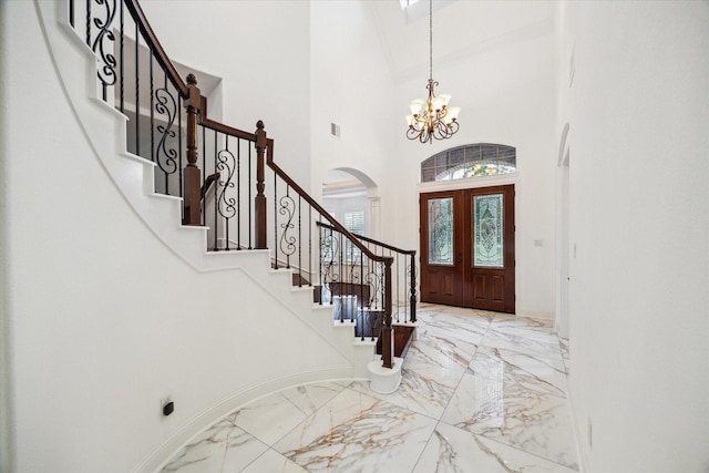 foyer featuring a chandelier, a high ceiling, and french doors