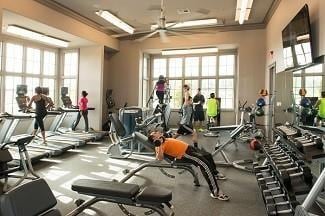 gym with ceiling fan and crown molding