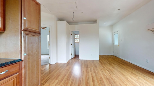 spare room featuring a wall unit AC and light wood-type flooring