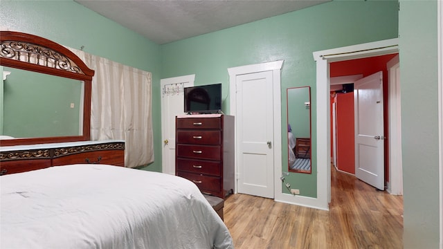 bedroom featuring a textured ceiling and light wood-type flooring