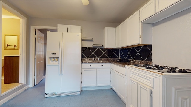 kitchen featuring decorative backsplash, white cabinetry, sink, and white appliances