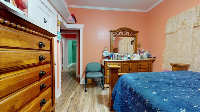 bedroom featuring crown molding and light hardwood / wood-style flooring