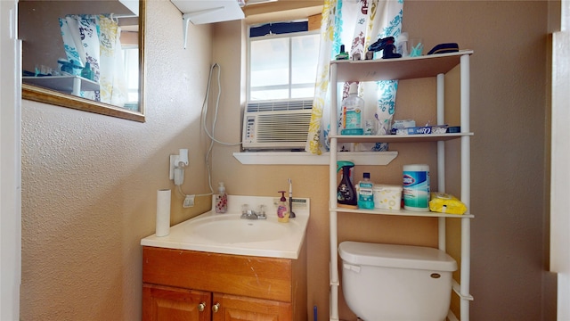 bathroom featuring vanity, cooling unit, and toilet