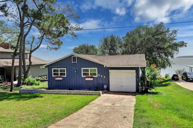 354 Edgewater Way, Point Blank, TX 77364 - view of front of home with board and batten siding, concrete driveway, a water view, and a front yard