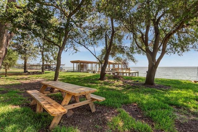 view of community featuring a lawn and a water view