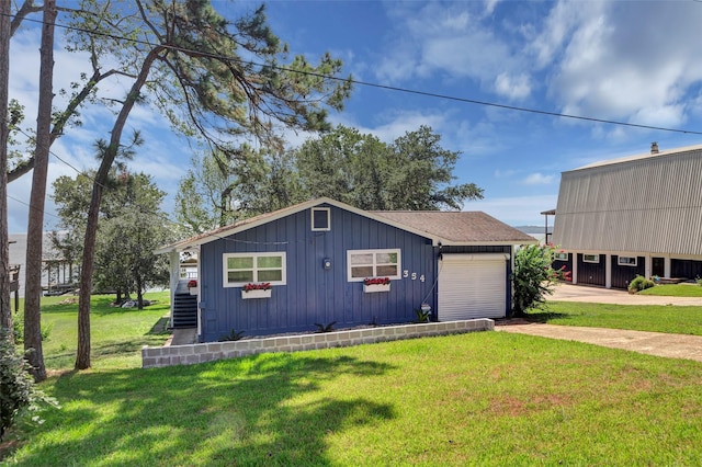 view of front of house with driveway, a garage, roof with shingles, board and batten siding, and a front yard