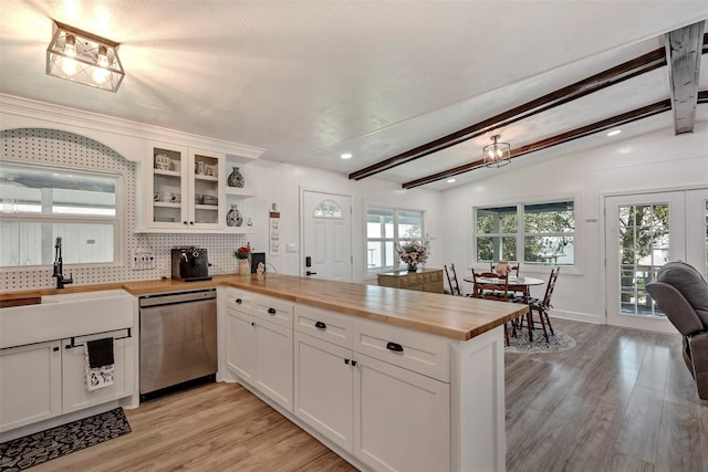 kitchen with dishwasher, sink, light wood-type flooring, white cabinets, and butcher block counters