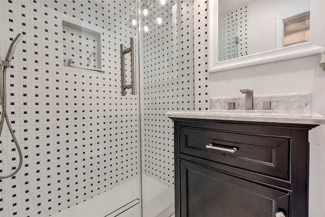 bathroom featuring vanity and a shower with door