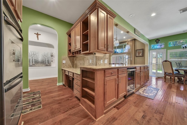 kitchen with pendant lighting, oven, tasteful backsplash, dark hardwood / wood-style flooring, and beverage cooler