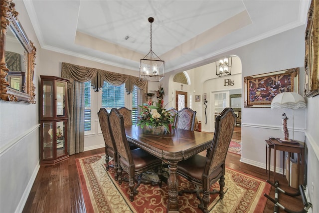 dining space with crown molding, dark wood-type flooring, and a tray ceiling