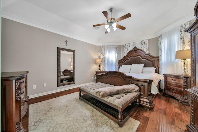 bedroom with dark hardwood / wood-style floors, ceiling fan, and crown molding