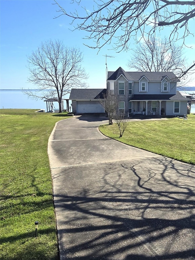 view of front of house featuring driveway, a porch, and a front yard