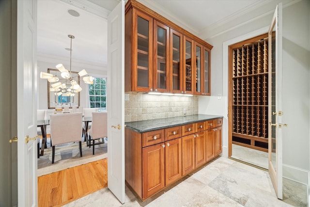 wine area featuring an inviting chandelier and ornamental molding